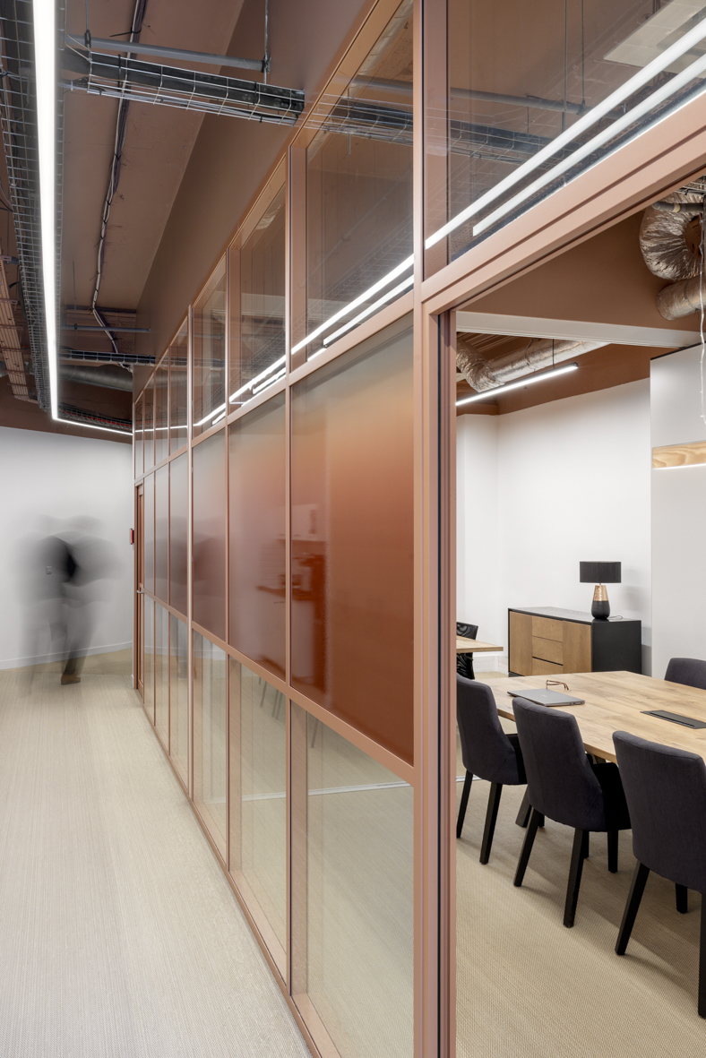 Circulation le long des salles de réunion aux cloisons vitrées terracotta, projet Ternes à Paris