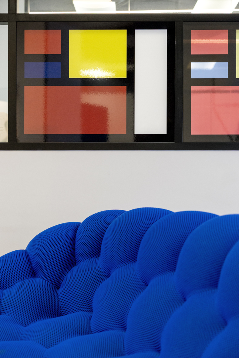 Verrière graphique inspirée de Mondrian au-dessus du canapé Bubble bleu, projet Ternes à Paris